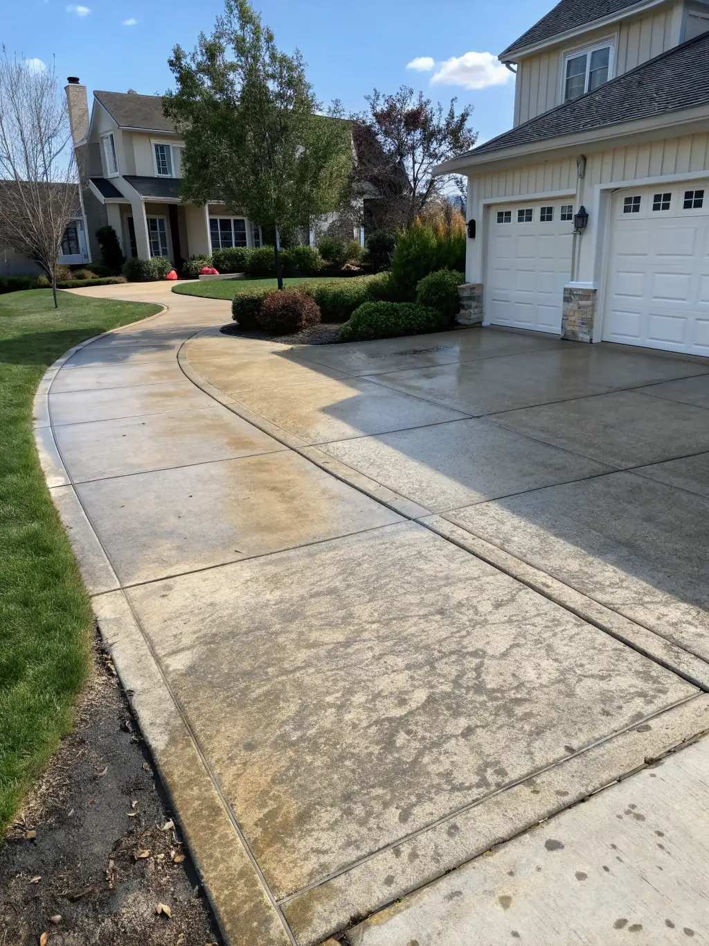 A before-and-after photo of a driveway, with one side stained and dirty and the other side clean and freshly power washed. The contrast should be striking.